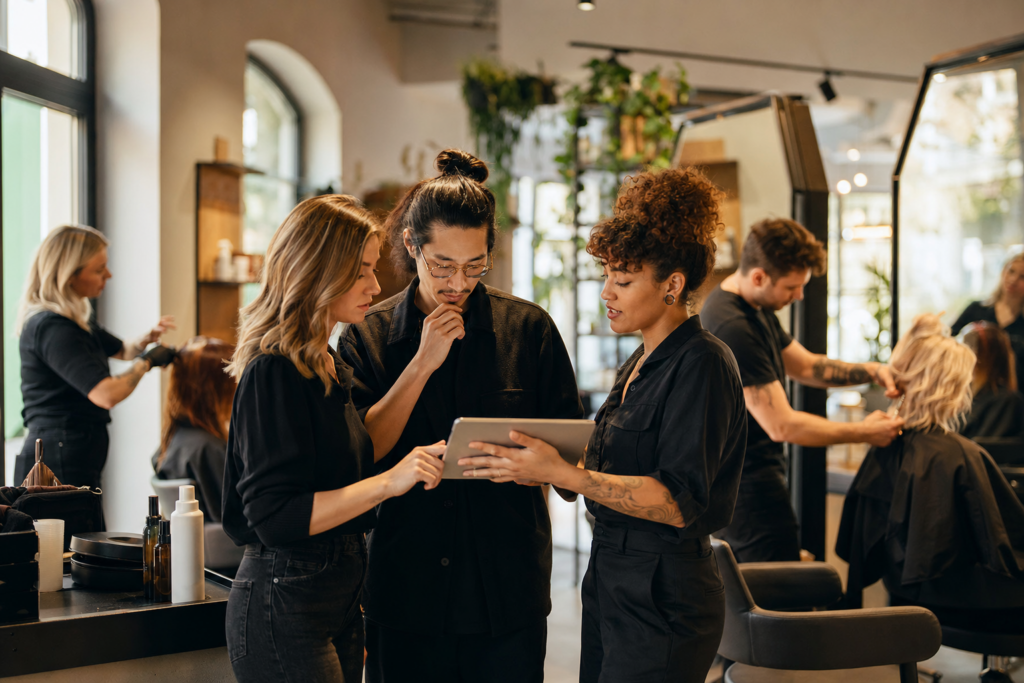 Friseurteam stimmt sich gemeinsam im gut besuchten Salon ab.